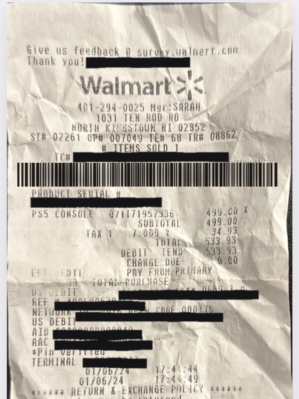 A heavily crumpled Walmart receipt photographed on a desk, creased and unevenly lit